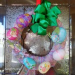 Festive and Frugal Easter wreath made with decoupaged eggs, ribbon, mesh and fabric scraps.