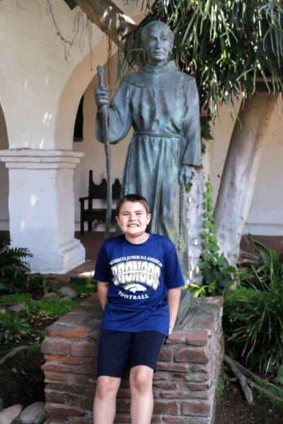 mission san diego boy in front of statue of Father Junipero Serra