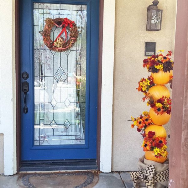 porch with Autumn pumpkin totem with silk flowers