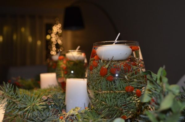 candle floating in a glass of greenery