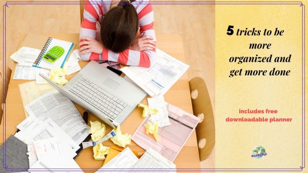 woman sitting with her head down at a disorganized table with text overlay "5 tricks to be more organized and get more done.