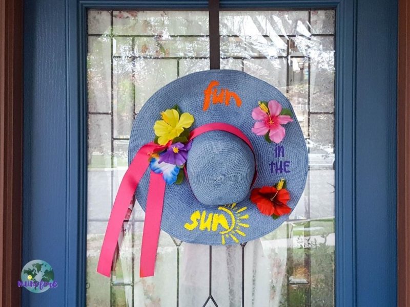 decorated sun hat hanging on a front door