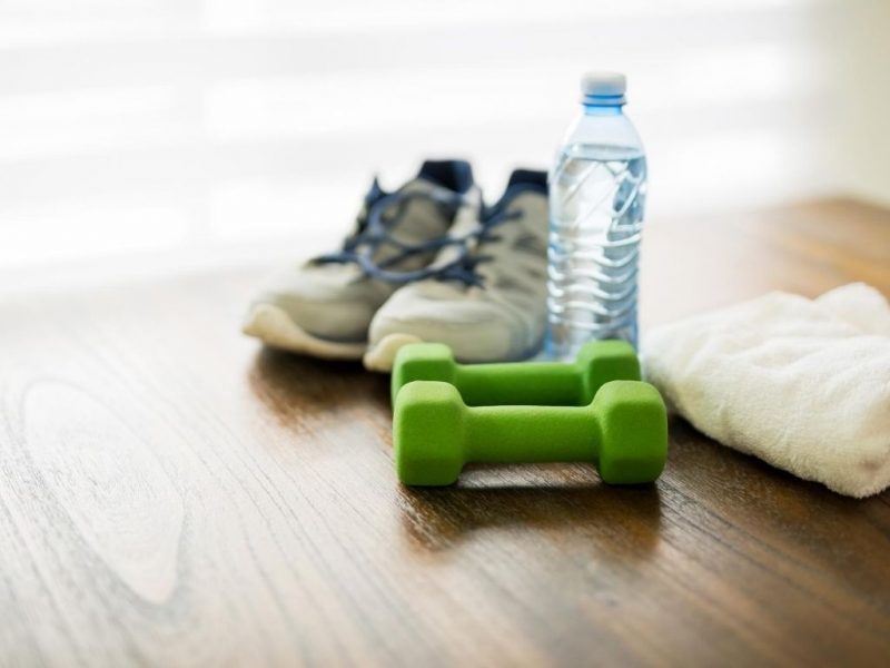 athletic shoes, water bottle a towel and small hand weights