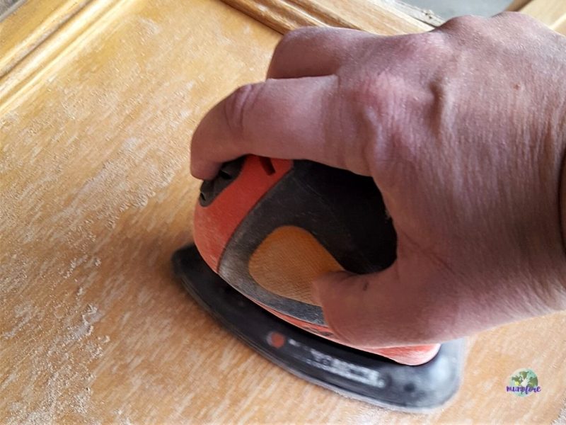 cabinet door being sanded with mouse sander