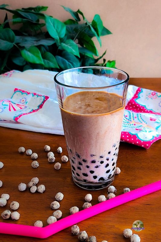 glass filled with iced coffee and boba